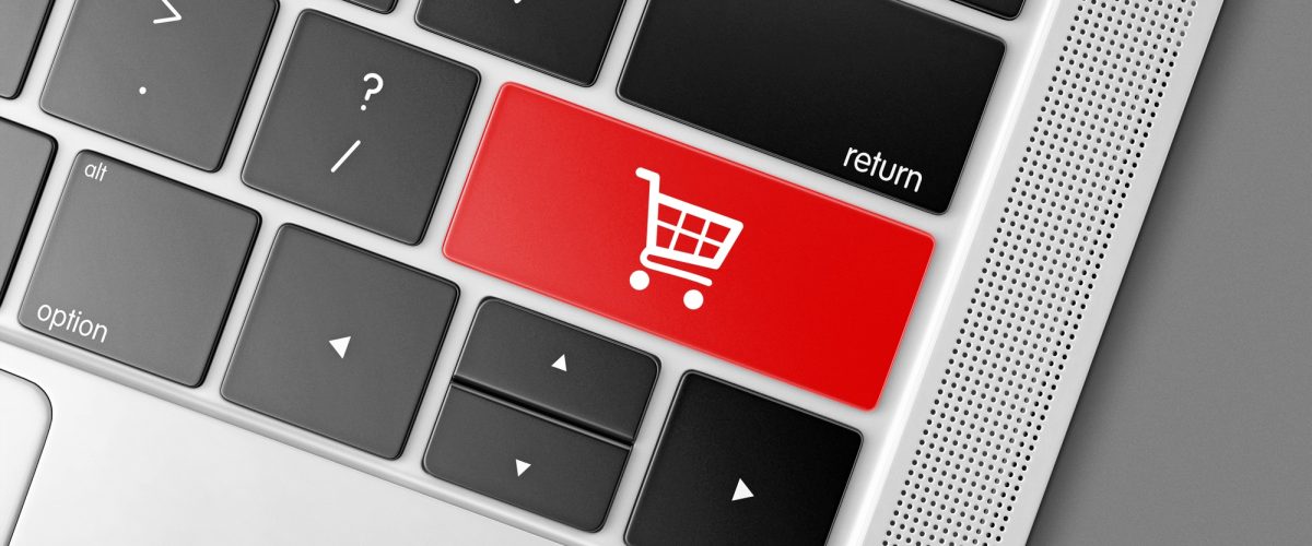 Red shopping cart key on a black computer keyboard, internet shopping concept picture Red shopping cart key on a black computer keyboard, internet shopping concept picture